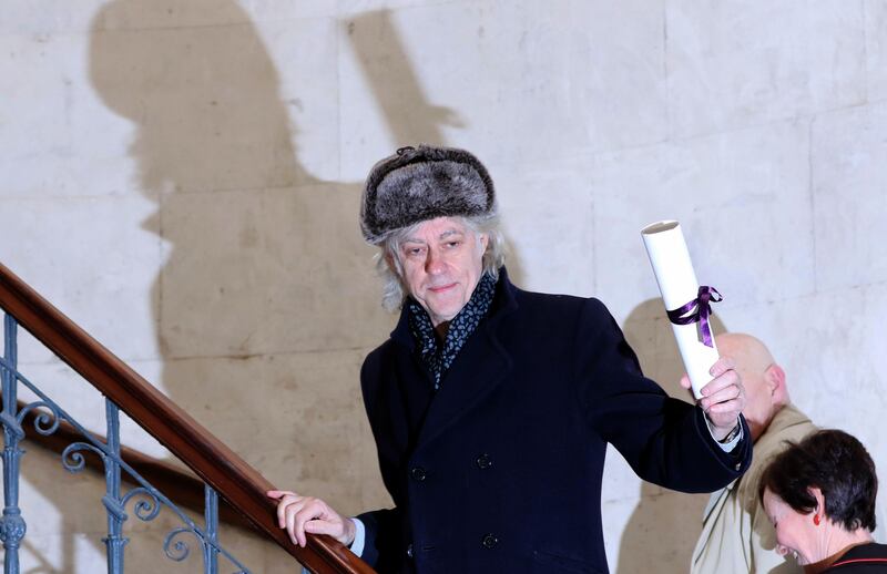 Irish musician Bob Geldof holds aloft his Freedom of the City of Dublin scroll as he prepares to return it at Dublin City Hall, in Dublin, on November 13, 2017.
Musician and Live Aid supremo Bob Geldof on Monday returned his Freedom of the City of Dublin award in a protest against Myanmar leader Aung San Suu Kyi, who holds the same honour. The Boomtown Rats singer slammed the Nobel peace laureate over her country's treatment of its Rohingya Muslim minority, calling her a "handmaiden to genocide" in a strongly worded statement. / AFP PHOTO / Paul FAITH
