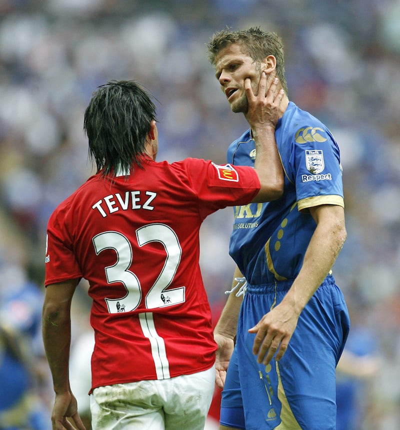 Manchester United's Argentinian player Carlos Tevez (L) pushes Portsmouth's Icelandic footballer Hermann Hreidarsson in the face after a challenge during the FA Community Shield between Manchester United and Portsmouth at the Wembley Stadium in London on August 10, 2008. AFP PHOTO/IAN KINGTON *** Local Caption ***  044770-01-08.jpg