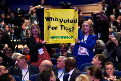 Greenpeace activists hold up a sign in protest during British Prime Minister Liz Truss's speech. Reuters