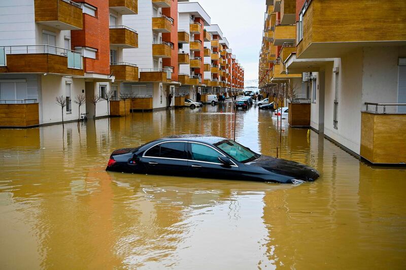 A picture shows a car submerged on a flooded street in the town of Fushe Kosove, after heavy rain and snow showers in Kosovo. AFP