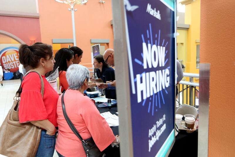 FILE - In this Oct. 1, 2019, file photo people wait in line to inquire about job openings with Marshalls during a job fair at Dolphin Mall in Miami. On Friday, Dec. 6, the U.S. government issues the November jobs report. (AP Photo/Lynne Sladky, File)