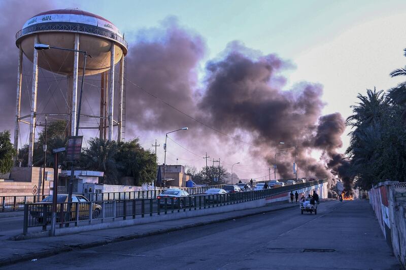 Iraqi Anti-government demonstrators block a road with debris and burning tires in the southern Iraqi city of Nasiriyah.   AFP