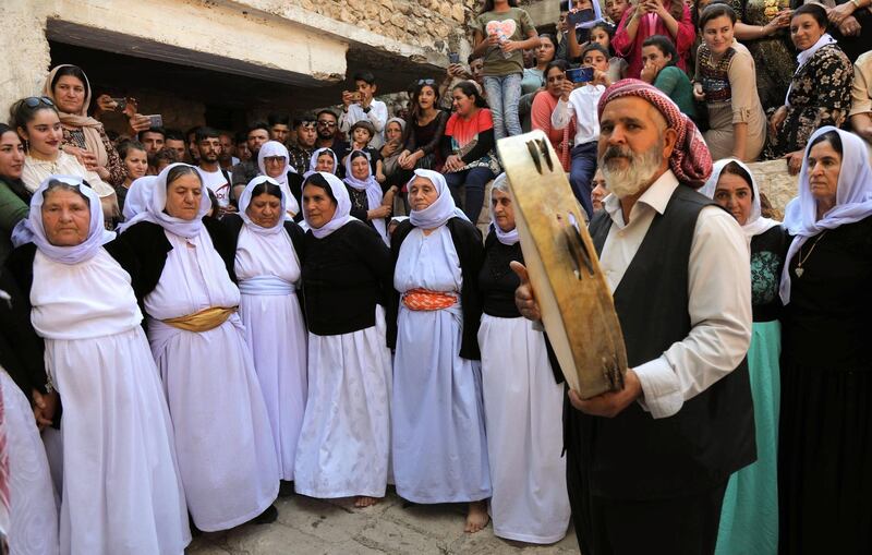 Iraqi Yazidis dance to traditional music at the Temple of Lalish, in a valley near the Kurdish city of Dohuk, about 430km northwest of the Iraqi capital Baghdad, on October 9, 2019. - Of the 550,000 Yazidis in Iraq before the Islamic State (IS) group invaded their region in 2014, around 100,000 have emigrated abroad and 360,000 remain internally displaced. (Photo by SAFIN HAMED / AFP)