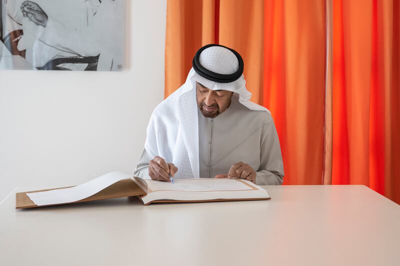 Sheikh Mohamed bin Zayed signs a guestbook during the tour. 