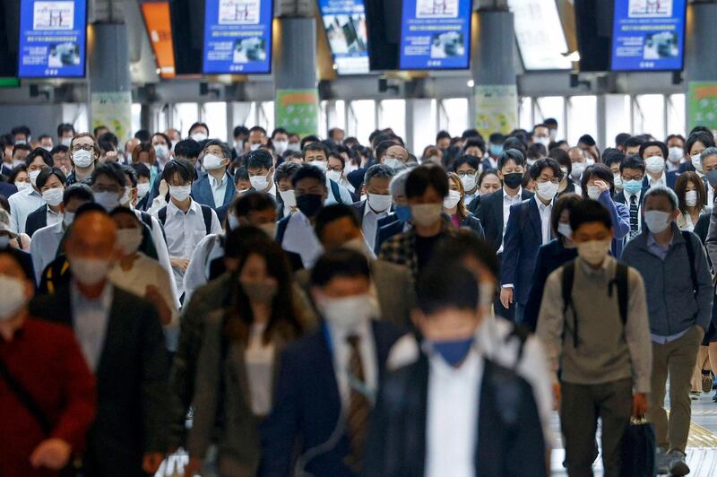 Masked commuters in a station passageway in Tokyo. AP Photo