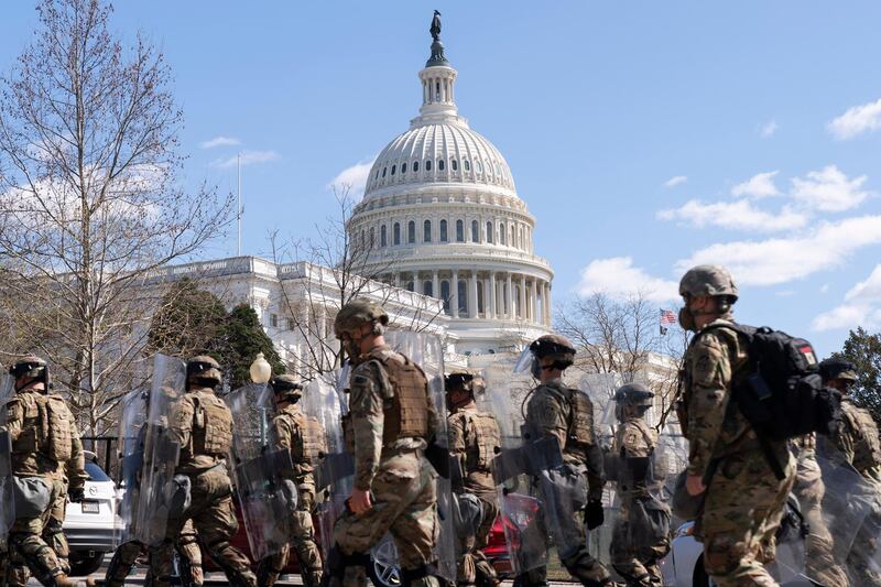 National Guard personnel leave the Capitol perimeter they had been guarding, with the Capitol dome prominent behind them. AP Photo