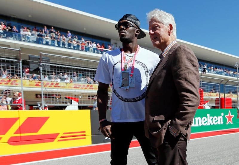Eight time Olympic gold medal winner Usain Bolt and former US President Bill Clinton stand on the track before the start of the race. Tony Gutierrez / AP Photo
