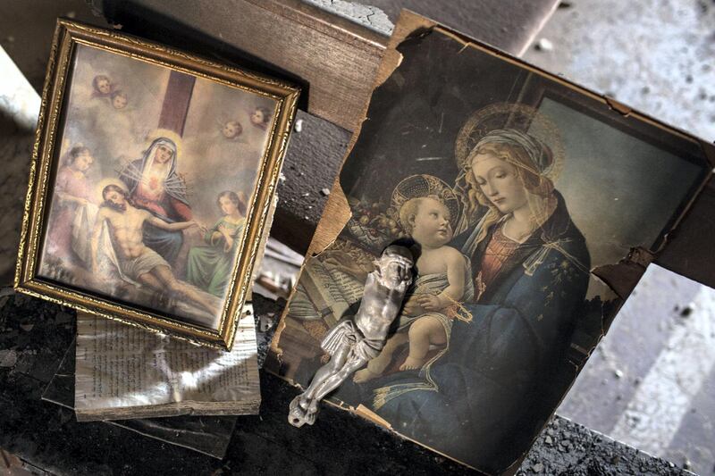 QARAQOSH, IRAQ - NOVEMBER 08: Damaged prints of Jesus Christ are seen inside the burnt and destroyed interior of the St Mary al-Tahira church on November 8, 2016 in Qaraqosh, Iraq. The NPU is a military organization made up of Assyrian Christians and was formed in late 2014 to defend against ISIL. Qaraqosh, a largely Assyrian City just 32km southeast of Mosul was taken by ISIL in August, 2014 forcing all residents to flee, the town was largely destroyed with all of the churches burned or heavily damaged. The town stayed under ISIL control last week when it was liberated during the Mosul Offensive.  (Photo by Chris McGrath/Getty Images)