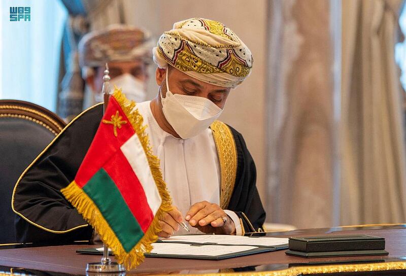 Omani Foreign Minister Sayyid Al Busaidi signing a deal.