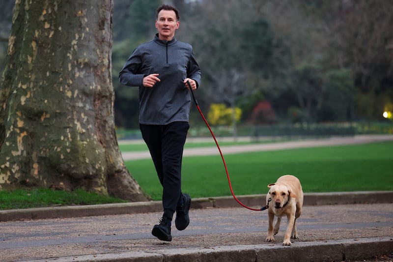 Mr Hunt gets some exercise with his dog Poppy before his budget statement. Reuters