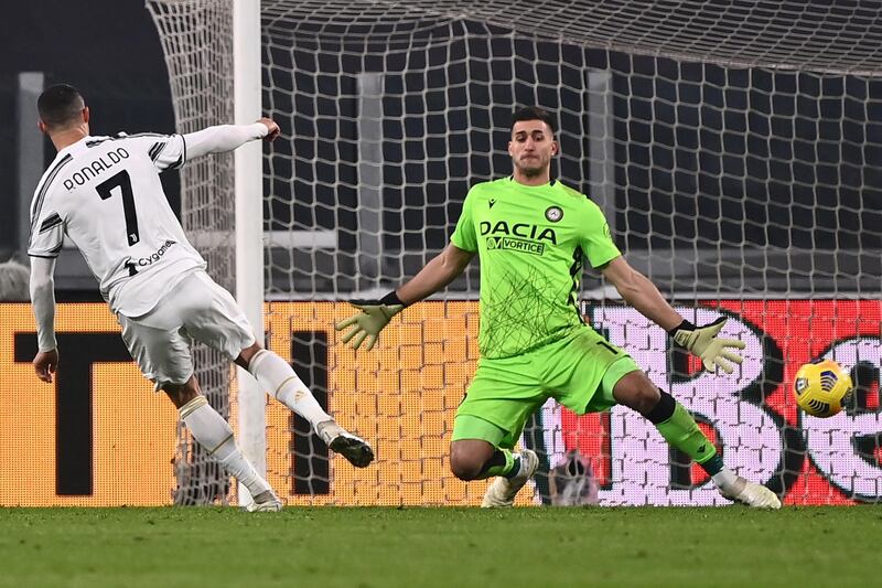 Juventus' Portuguese forward Cristiano Ronaldo (L) scores his second goal past Udinese's Argentine goalkeeper Juan Musso during the Italian Serie A football match Juventus vs Udinese on January 3, 2021 at the Juventus stadium in Turin. (Photo by Marco BERTORELLO / AFP)