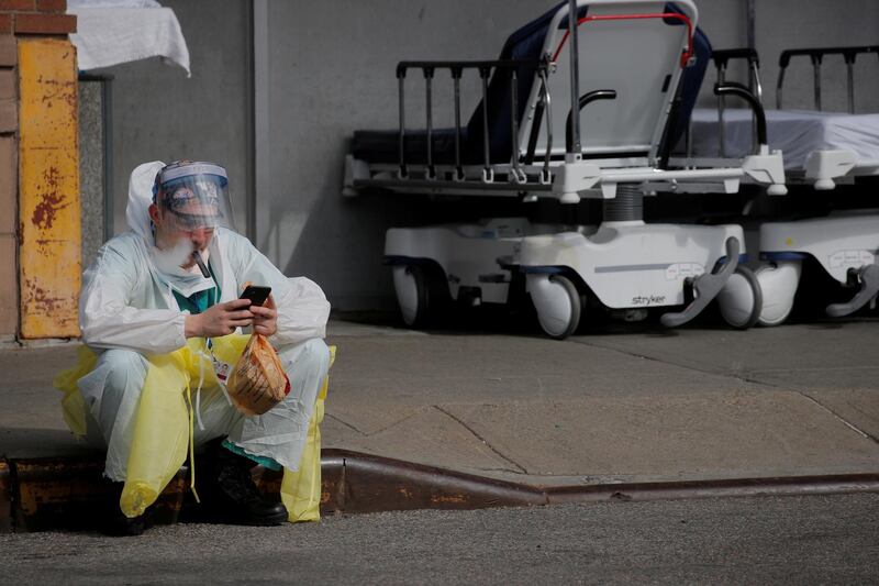 A healthcare worker sits on the curb as he uses a vaping device while taking a break outside Maimonides Medical Center during the outbreak of coronavirus in the Brooklyn borough of New York City, New York, US. Reuters