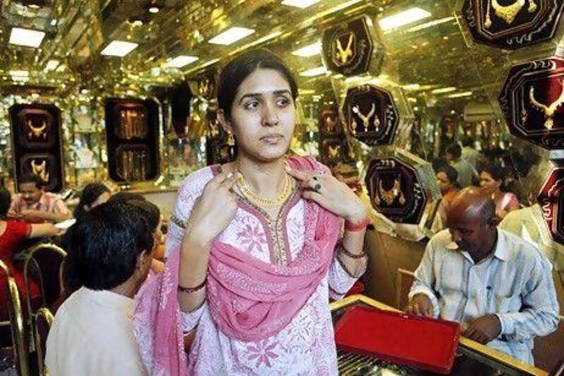 A woman selects gold ornaments before Diwali, in Allahabad, India. Shop owners say the expense of gold jewellery is dampening demand. Rajesh Kumar Singh / AP Photo