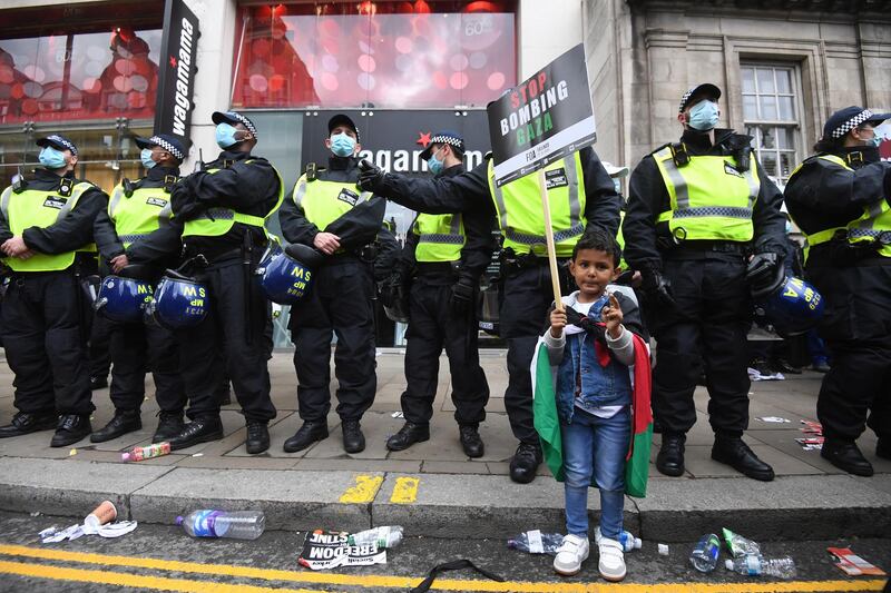A young Palestine supporter carries a placard in front of riot police during a demonstration outside the Israeli embassy in London, Britain. EPA