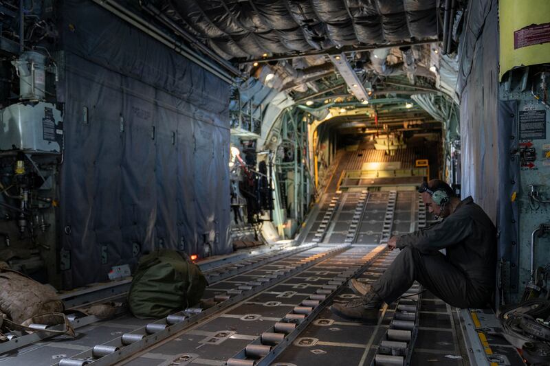 A Jordanian Air Force loadmaster sits in the empty cargo hold as the flight makes its way back to the airbase in Jordan. 