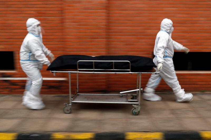 Nurses take the body of Isidra Coronel to the morgue after removing her body from a hospital bed where she died from the new coronavirus at Hospital de Clinicas in San Lorenzo, Paraguay.  AP Photo