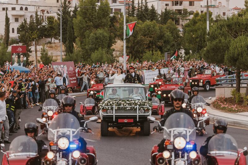 Prince Hussein and Princess Rajwa wave from their motorcade. Reuters