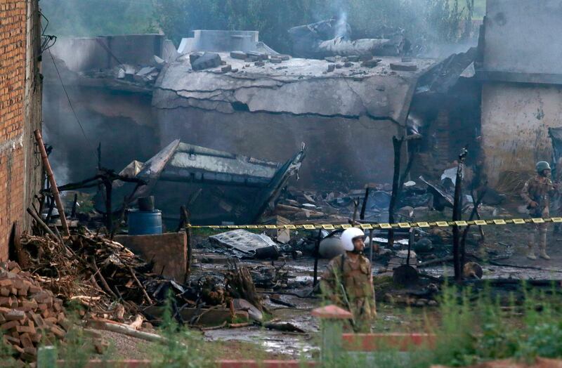 An rrmy soldier stands guard the site of the plane crash. AP Photo