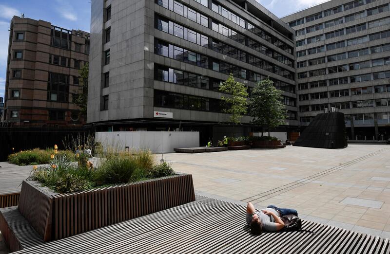 A man rests in an almost empty area in the City of London financial district, following the outbreak of the coronavirus disease (COVID-19) in London, Britain. REUTERS