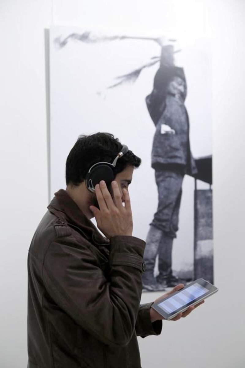 A visitor listens to the audio tracks supplied on an IPad to visitors of the UAE's first sound art exhibition being held at DUCTAC in Mall Of The Emirates. Antonie Robertson / The National