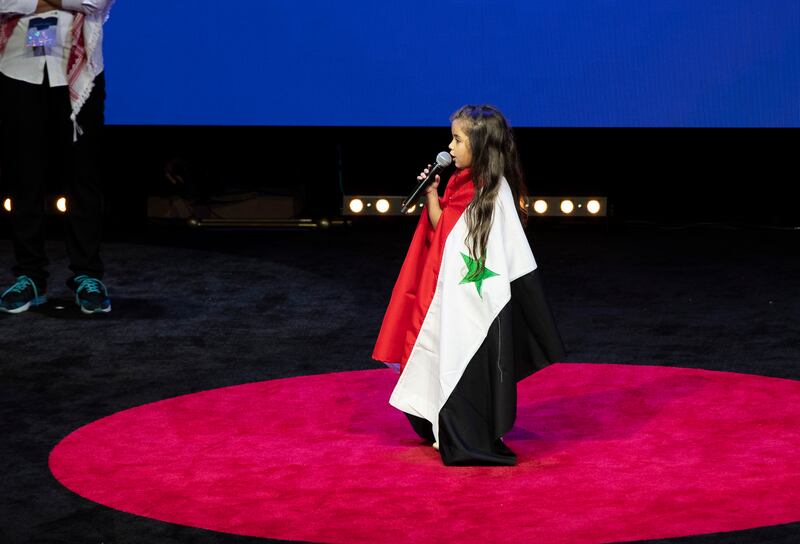 Sham Bakour was draped in a Syrian flag as she spoke to attendees.