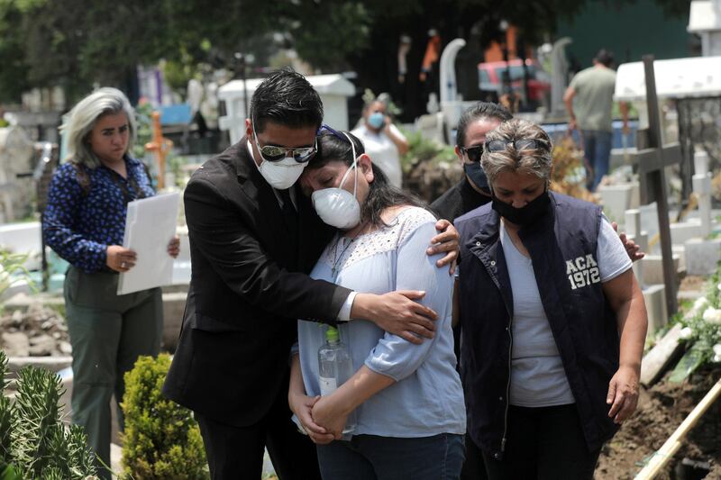 Relatives react near the coffin of a man, during his funeral at cemetery in Mexico City, Mexico. Reuters