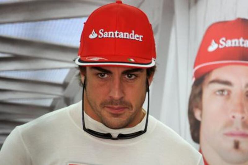 Ferrari's Spanish driver Fernando Alonso stands in the pits on April 20, 2012 during the first practice session at the Bahrain International Circuit in Manama ahead of the Bahrain Formula One Grand Prix. AFP PHOTO / DIMITAR DILKOFF