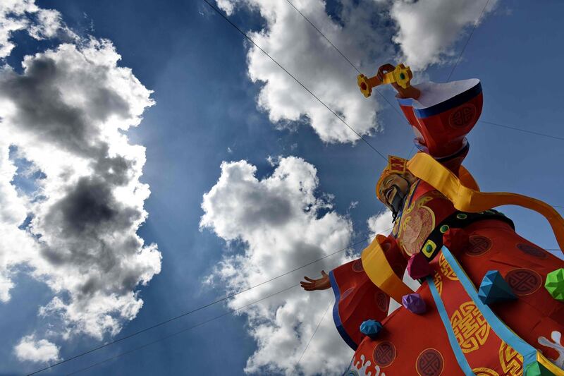 A huge figurine of the 'God of Fortune' dons the sky in Singapre's financial district ahead of Lunar New Year celebrations.  Roslan Rahman  / AFP Photo