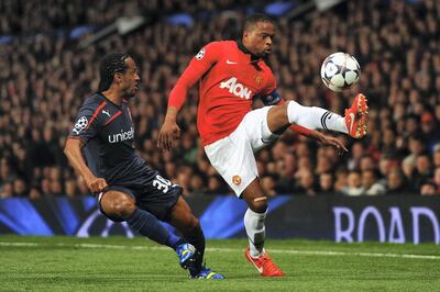 MANCHESTER, ENGLAND - MARCH 19:  Patrice Evra of Manchester United competes with Leandro Salino of Olympiacos during the UEFA Champions League Round of 16 second round match between Manchester United and Olympiacos FC at Old Trafford on March 19, 2014 in Manchester, England.  (Photo by Laurence Griffiths/Getty Images)