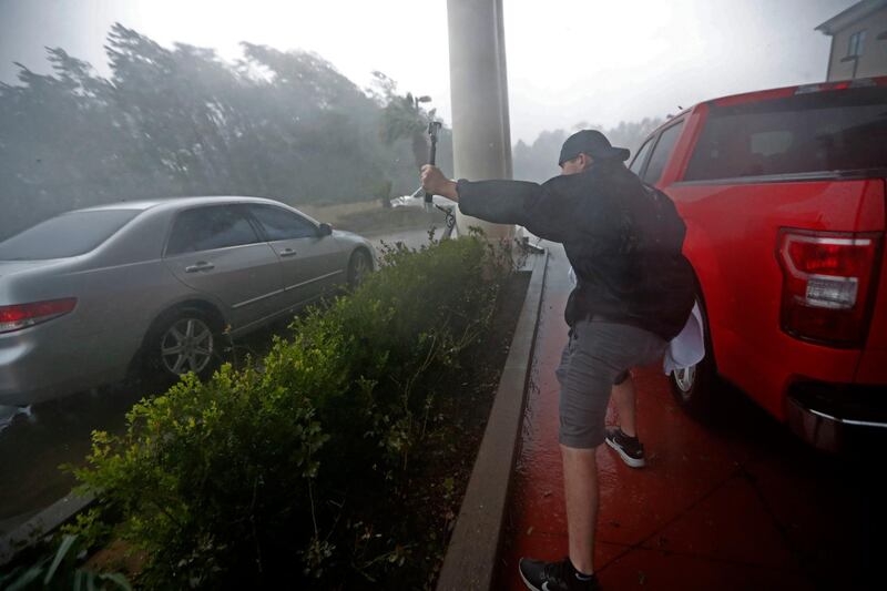 A storm chaser films from underneath a hotel canopy in Panama City Beach. AP