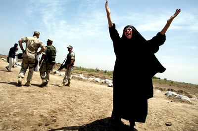 A woman cries out the name of her missing son as US Marines search for evidence at a mass grave in 2003, in Hillah. Getty     
