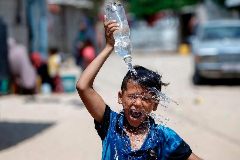 A Palestinian boy pours water over his head in Khan Yunis in the southern Gaza Strip.  AFP