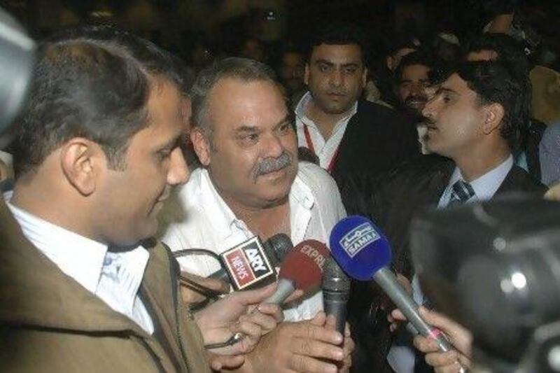 Australian Dav Whatmore, centre, is surrounded by reporters upon his arrival at Lahore airport in Pakistan today. Hamza Ahmed / AP Photo