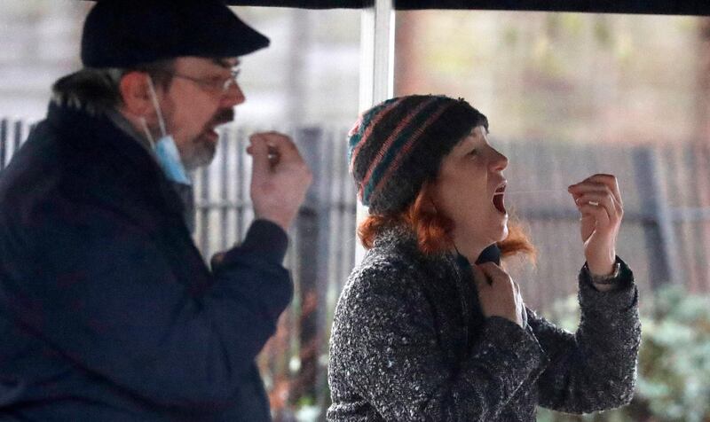 People take their own Covid-19 swab test at a newly built testing facility in a car park in West Ealing, London, after it emerged that the South African variant of the coronavirus may have been identified in the local community. AP Photo