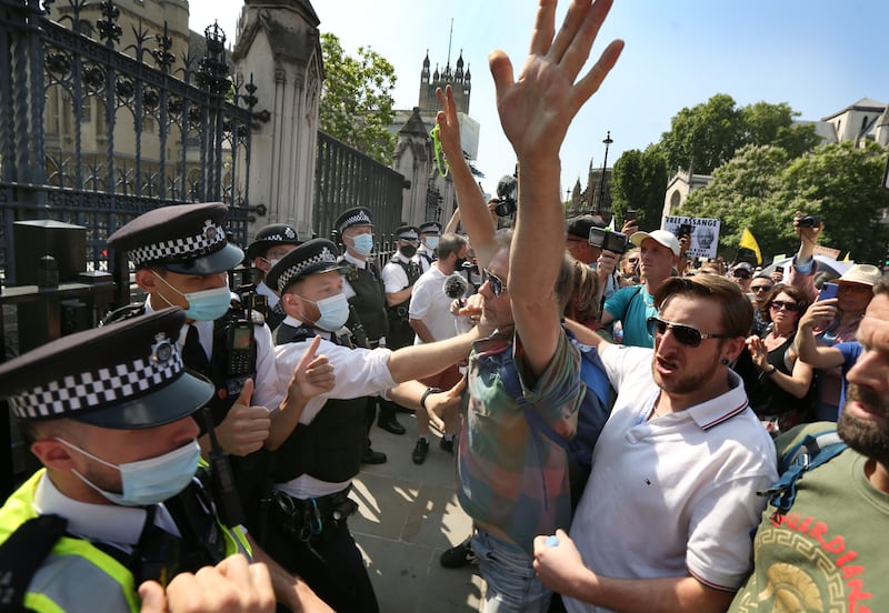 Protesters confront a police line outside the House of Commons during a freedom protest in London.