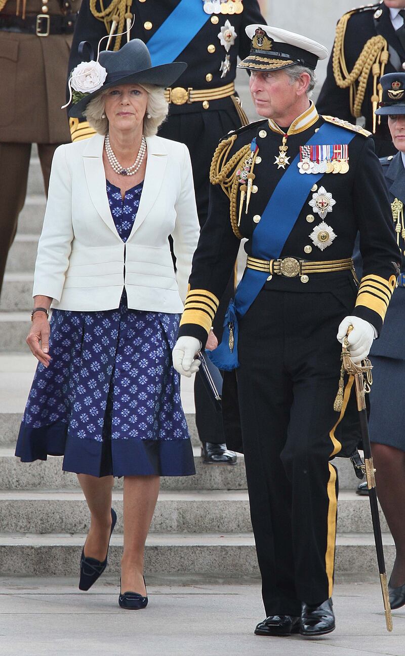 The queen consort, wearing a blue printed dress, and King Charles after a Falklands War flypast on June 17, 2007 in London. Getty Images