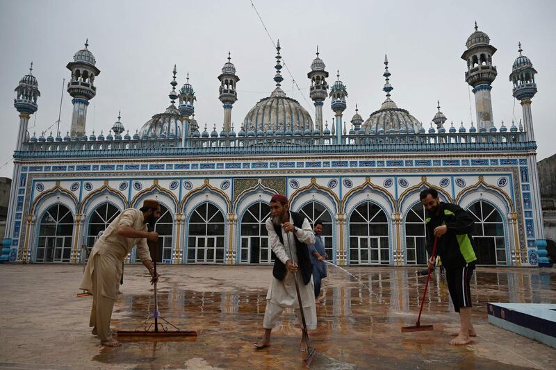 Muslim devotees wash the floor of the Jamia Mosque in Rawalpindi, Pakistan, ahead of Ramadan, following new government restrictions to contain the spread of Covid-19. AFP