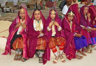EK4775 Omani girls in traditional dress take a break during a cultural festival in Muscat, in the Sultanate of Oman. Alamy