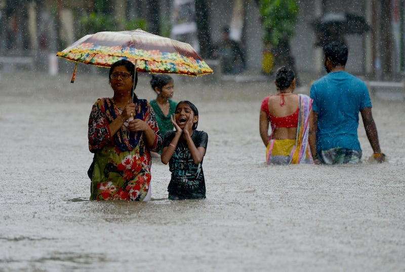 TOPSHOT - Indians wade through a flooded street during heavy rain showers in Mumbai on August 29, 2017.
Heavy rain brought India's financial capital Mumbai to a virtual standstill on August 29, flooding streets, causing transport chaos and prompting warnings to stay indoors. Dozens of flights and local train services were cancelled as rains lashed the coastal city of nearly 20 million people.
 / AFP PHOTO / PUNIT PARANJPE