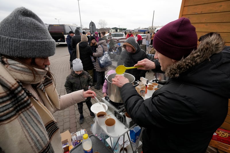 Refugees fleeing the fighting in Ukraine queue for hot drinks at the border crossing in Medyka, south-east Poland. AP Photo