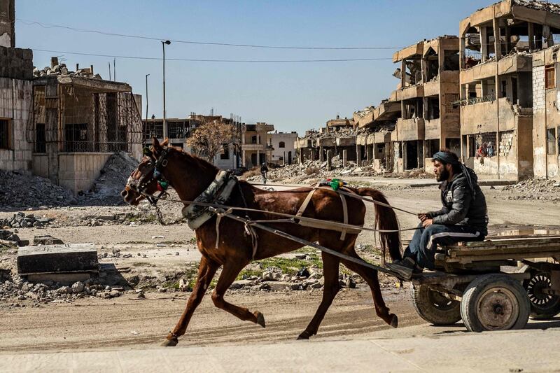 A man rides a horse and cart past damaged buildings in the northern Syrian city of Raqqa. AFP