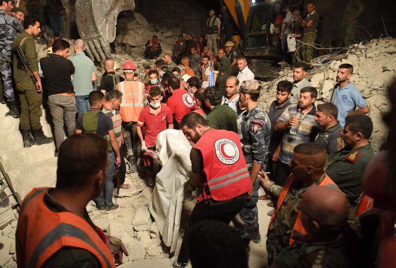 Rescuers remove the body of a victim from the rubble of a building that collapsed in Syria's northern city of Aleppo. AFP