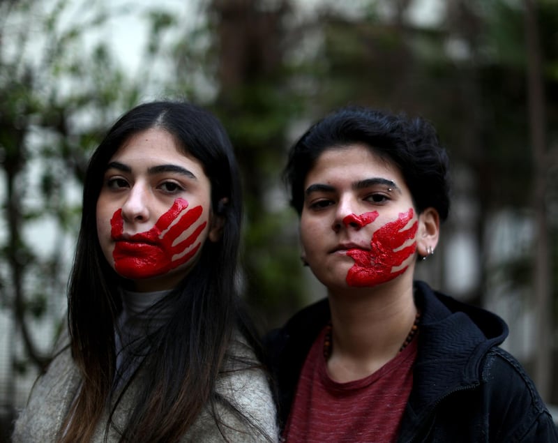 Lebanese women pose with their face painted with a red hand as they take part in a demonstration against sexual harassment, rape and domestic violence in the Lebanese capital Beirut. AFP
