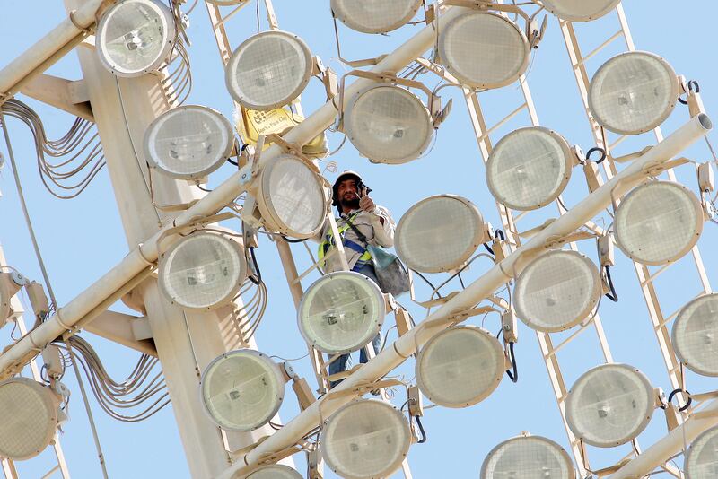 ABU DHABI , UNITED ARAB EMIRATES Ð Oct 9 : One of the maintenance worker on one of the light pole during the ACC Trophy Elite UAE 2012 cricket match between Kuwait vs Saudi Arabia at Zayed Cricket stadium in Abu Dhabi. ( Pawan Singh / The National ) For Focal Point
