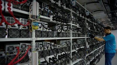 An employee inspects machines for the production of Bitcoin at a mining centre in Kirishi, Russia. AFP