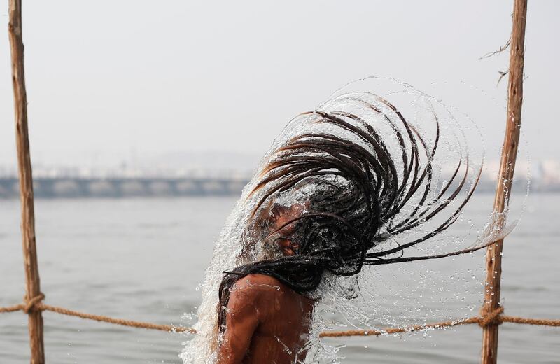 A Sadhu or a Hindu holy man takes a dip at Sangam, the confluence of the Ganges, Yamuna and Saraswati rivers, during 'Kumbh Mela', or the Pitcher Festival, in Prayagraj, previously known as Allahabad, India. REUTERS