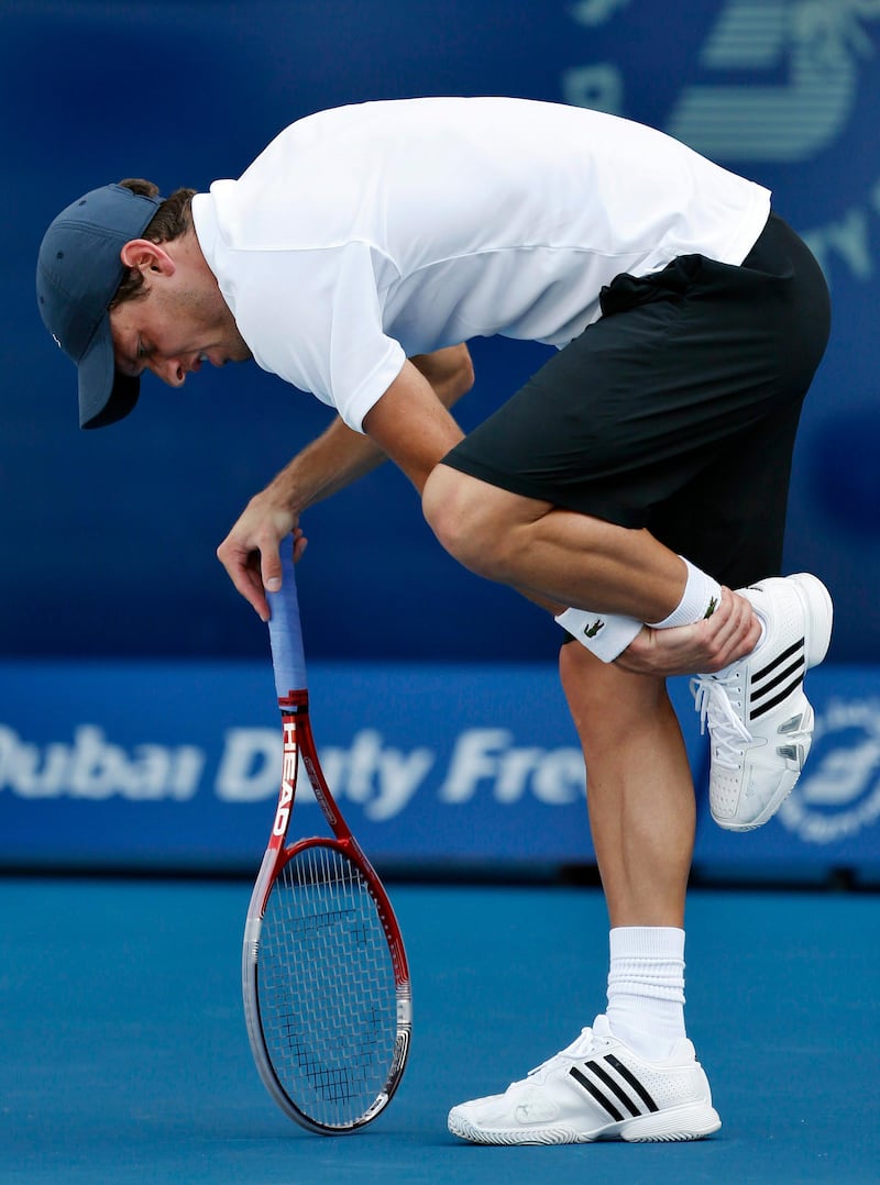 Tobias Kamke of Germany reacts after injuring his leg during his men's singles match against Tomas Berdych of Czech Republic at the ATP Dubai Tennis Championships, February 27, 2013. REUTERS/Mohammed Salem (UNITED ARAB EMIRATES - Tags: SPORT TENNIS) *** Local Caption ***  MJS25_TENNIS-MENS-D_0227_11.JPG