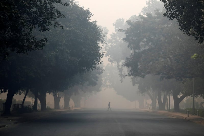A commuter crosses a road on a smoggy morning in New Delhi, India. Reuters