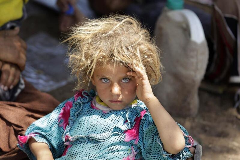 A girl from the minority Yazidi sect, fleeing the violence in the Iraqi town of Sinjar, rests at the Iraqi-Syrian border crossing in Fishkhabour, Dohuk province, in this August 13 file photo. Youssef Boudlal / Reuters