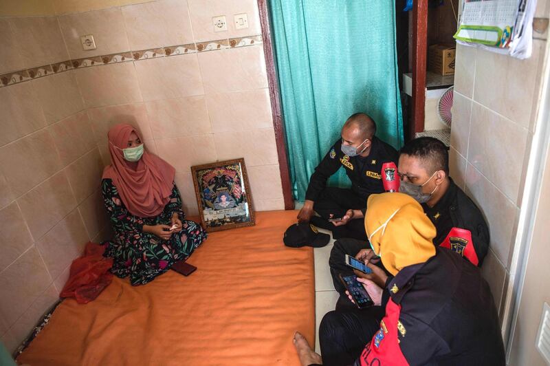 Berda Asmara (L) and family members gather to wait for news of her sailor husband Mes Guntur Ari Prasetyo at their home in Surabaya. AFP